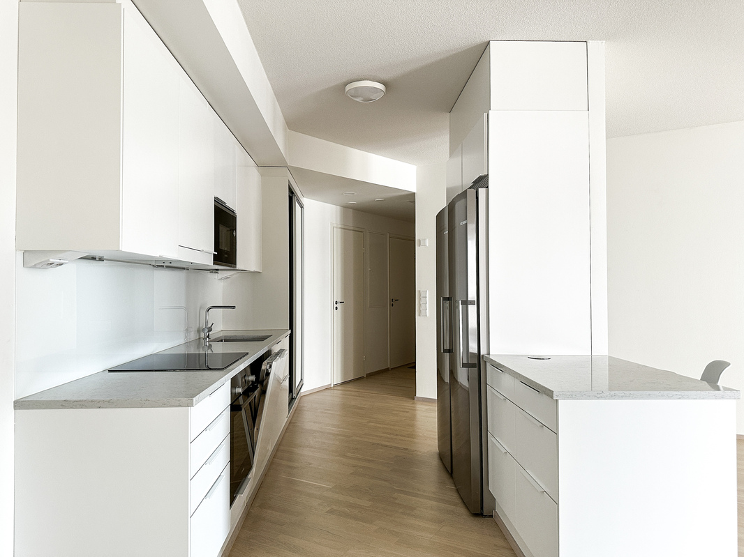 Keittiössä täysikokoinen jääkaappi ja pakastin