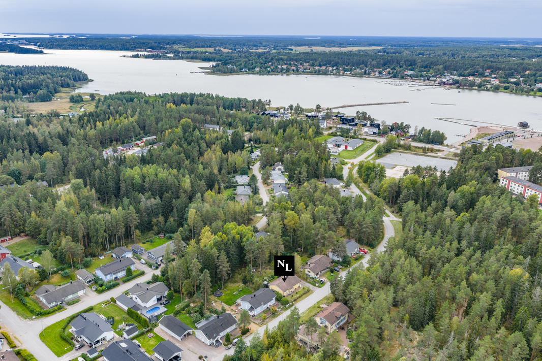 Ilmakuva talosta ja asuinalueesta meren äärellä