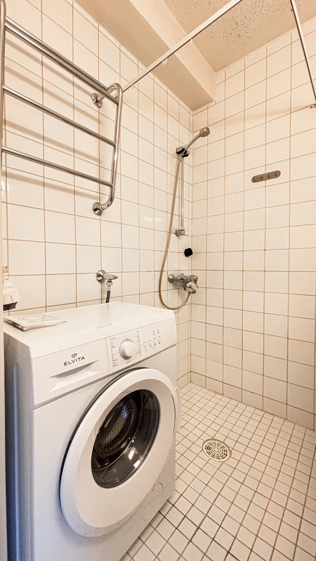 Kylpyhuoneessa valmiiksi pesukone