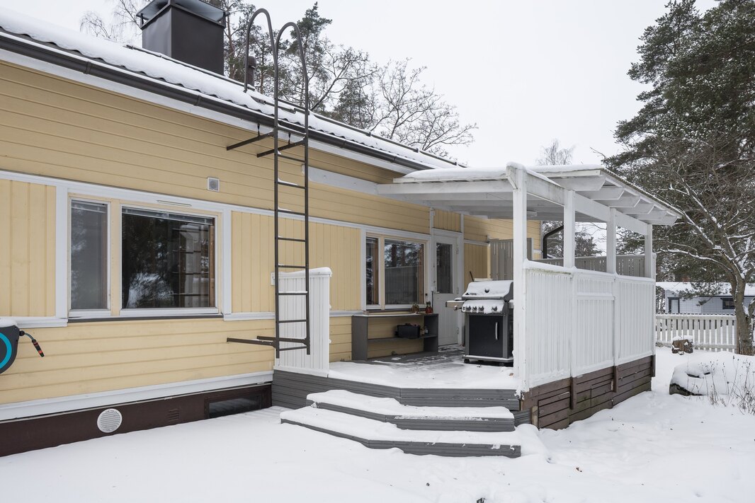 Takapihan katettu terassi jatkuu talon vieressä kattamattomana.