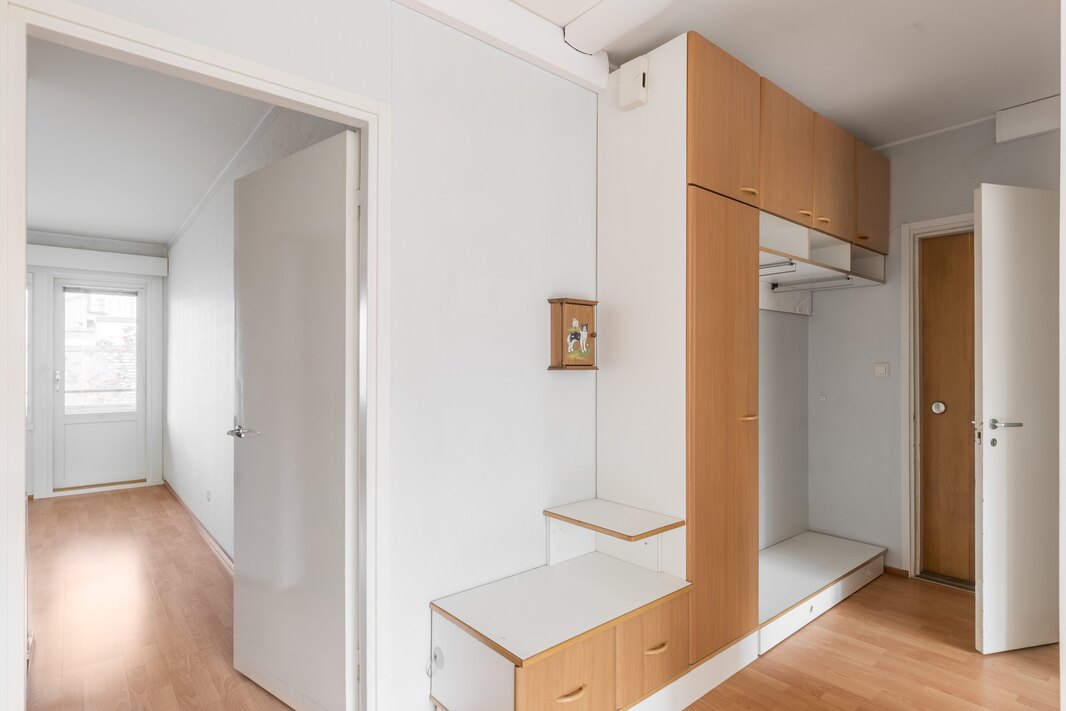 Eteisen kaapistossa on päädyssä vanhanajan puhelinpöytä.