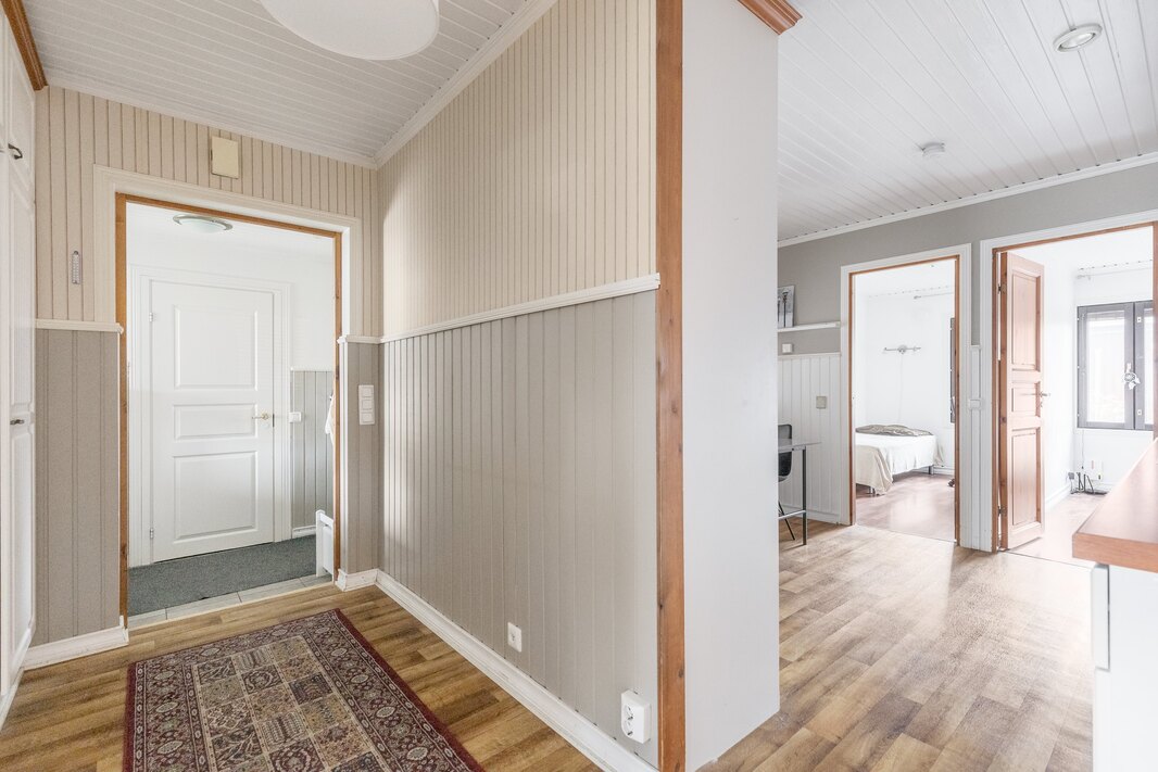 Näkymä eteiseen ja keittiöön, käytävän päässä oleva valkoinen ovi on varastoon/vaatehuoneeseen.