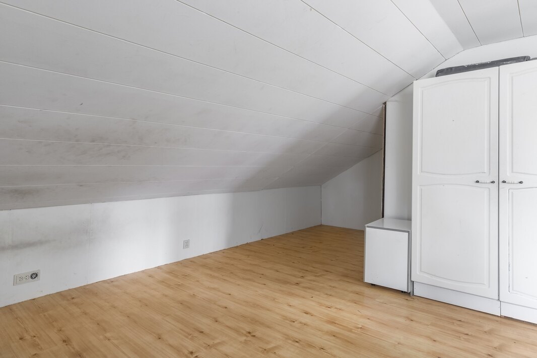 Ensimmäinen yläkerran makuuhuoneista jatkuu lappeen alle.