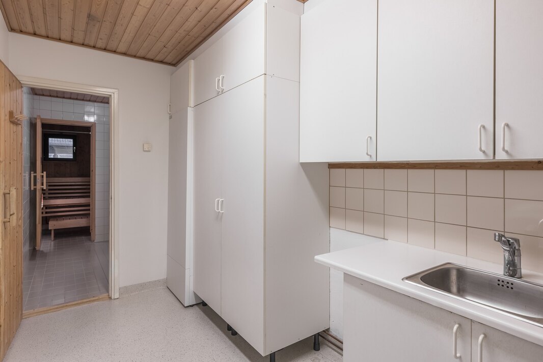 Kodinhoitohuoneen jatkona kylpyhuone ja sauna.