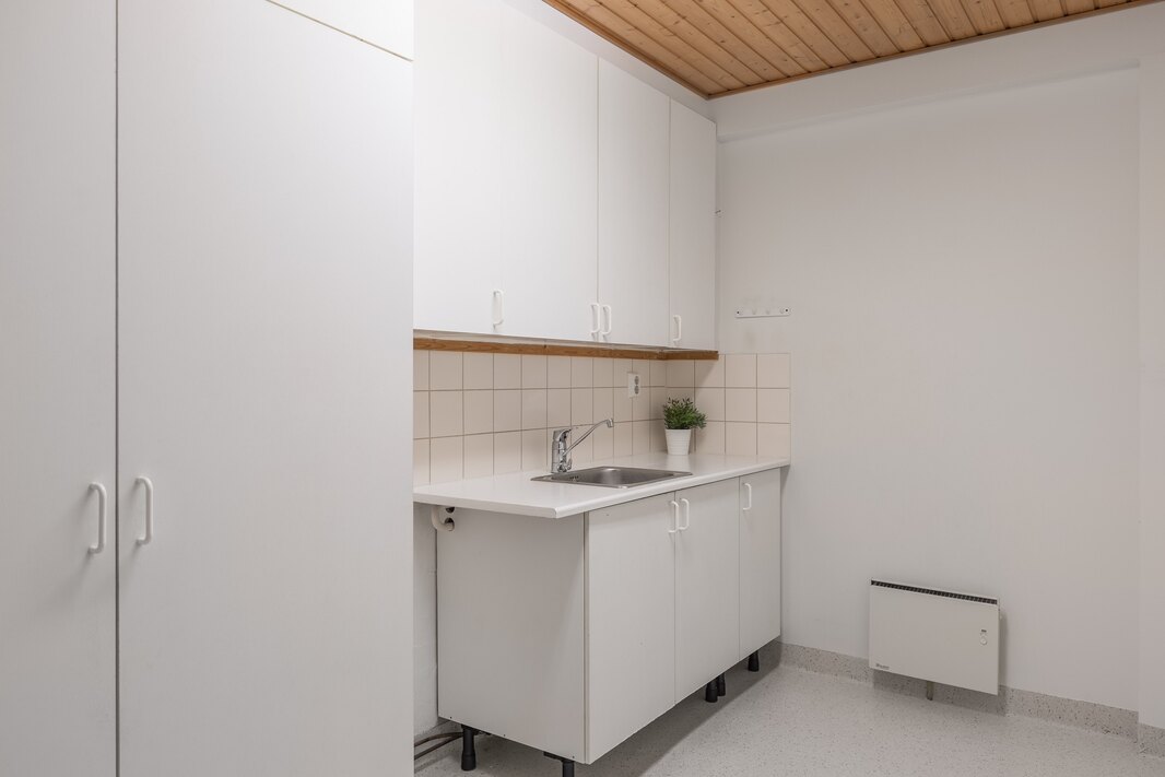 Kodinhoitohuoneessa on vesipiste ja kaapistot sekä paikka pyykinpesukoneelle.