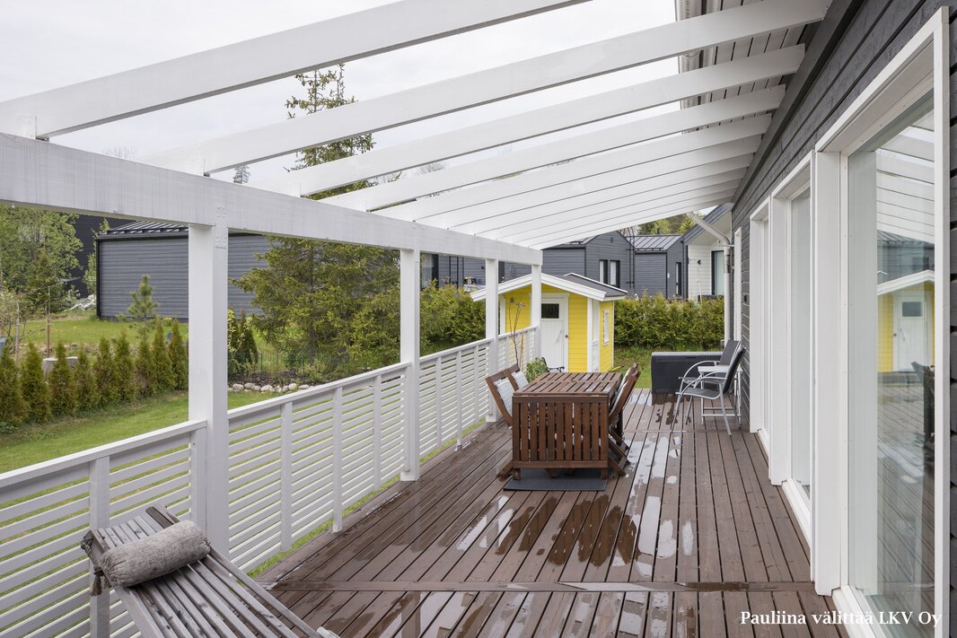 Terassipergola on lähes koko talon levyinen.