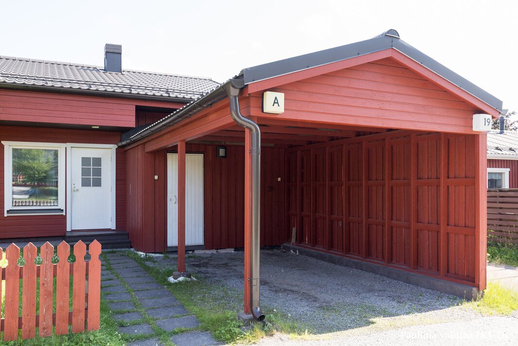Sisäänkäynnin yhteydessä autokatos ja ulkovarasto