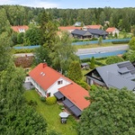 Talo vehreiden puiden ympäröimänä