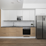 Keittiössä integroitu astianpesukone, induktioliesi, erillisuuni ja side-by-side jääkaappipakastin.