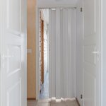 Eteiskäytävän ja kodinhoitohuoneen välissä paljeovi.