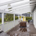 Terassipergola on lähes koko talon levyinen.