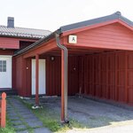 Sisäänkäynnin yhteydessä autokatos ja ulkovarasto