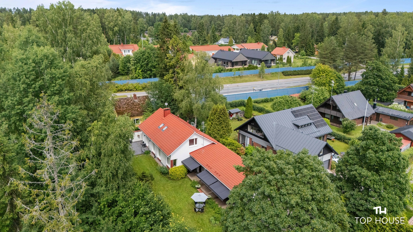 Talo vehreiden puiden ympäröimänä
