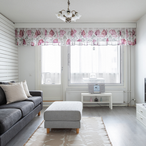 Valoisa olohuone, josta käynti lasitetulle parvekkeelle