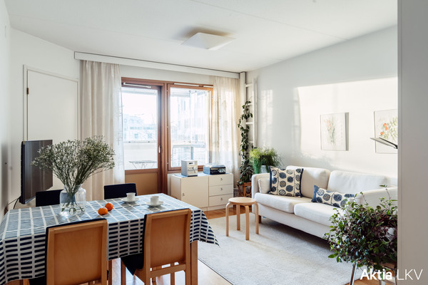 Valoisa olohuone, josta pääsy lasitetulle parvekkelle