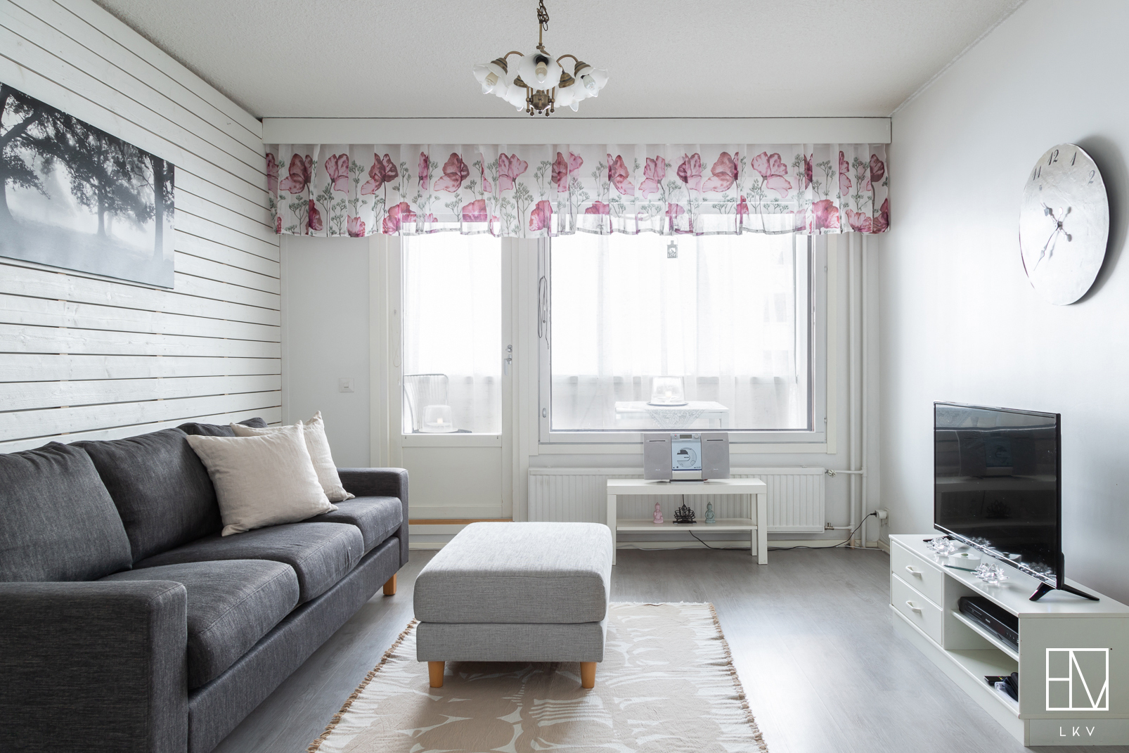 Valoisa olohuone, josta käynti lasitetulle parvekkeelle