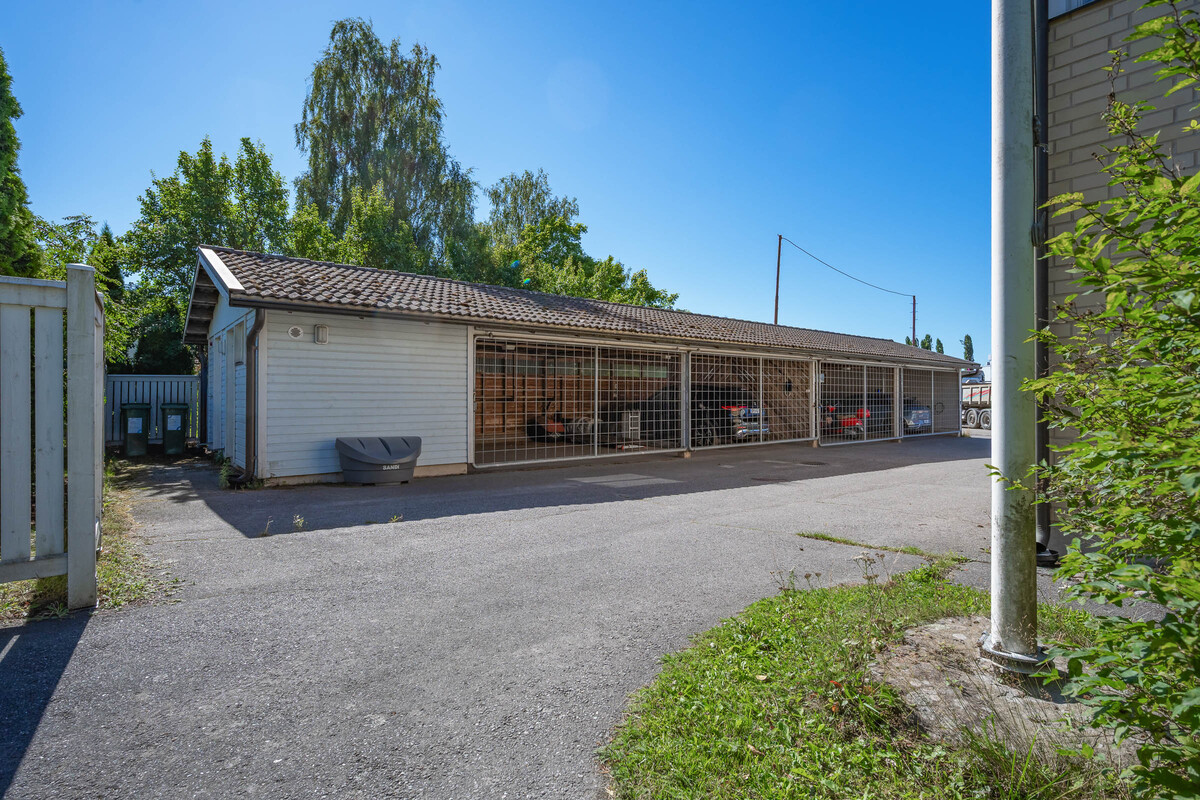 Kahden auton katospaikka, jossa toisessa auton sähkölatauspaikka.